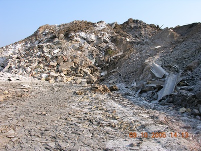 Zerfahrene Faserzementplatten vor einem Berg aus Asbestabfällen