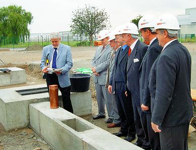 Grundstein für eine neue Auseinandersetzung: Im Beisein der Landräte Michael Czupalla (Delitzsch, Dritter von rechts) und Ulrich Gerstner (Salzlandkreis) bereitet KWD-Projektleiter Frank Dietzel (links) die Kassette zur Grundsteinlegung für das Bernburger Werk vor. Foto: Thomas Steingen